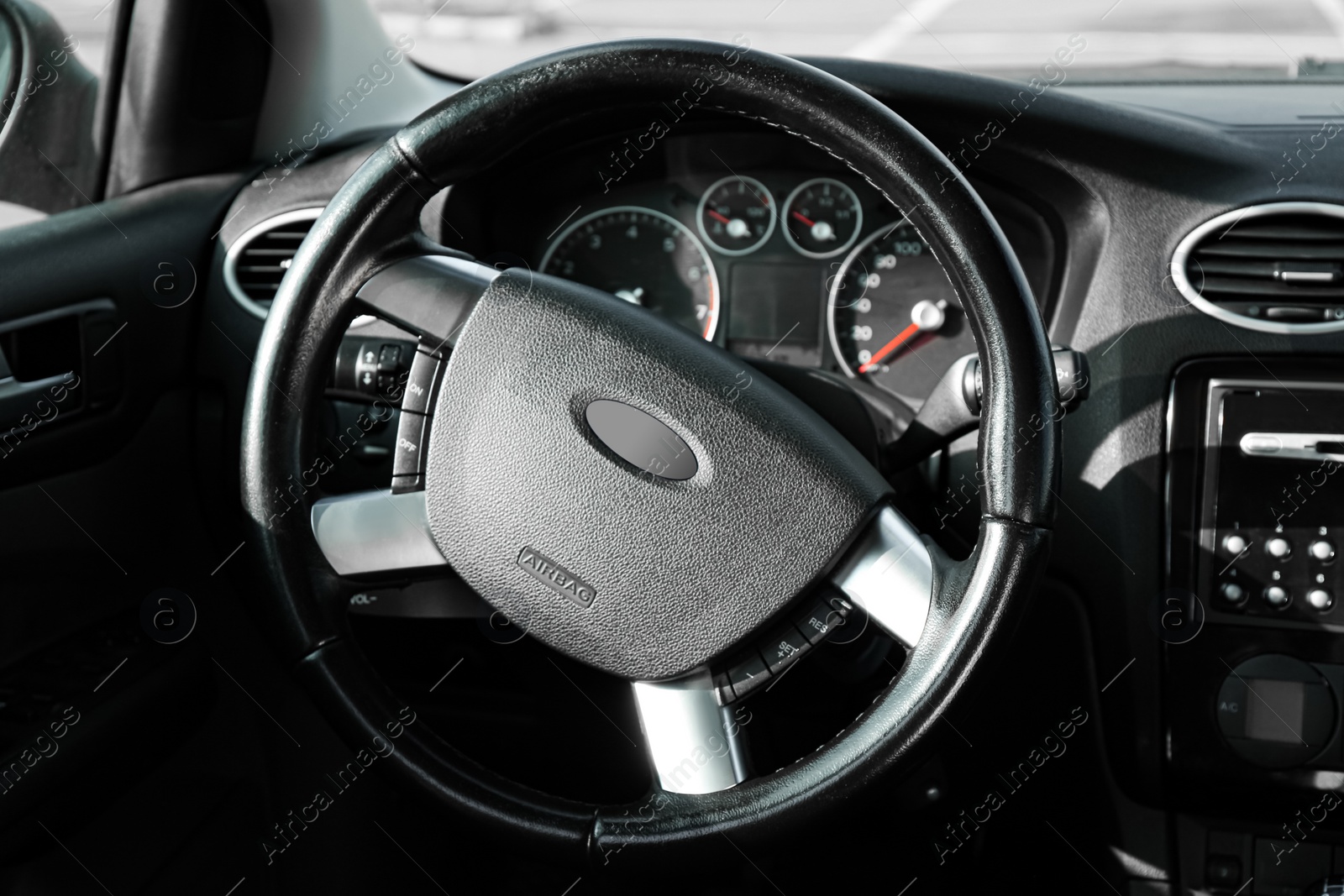 Photo of Black steering wheel and dashboard in car