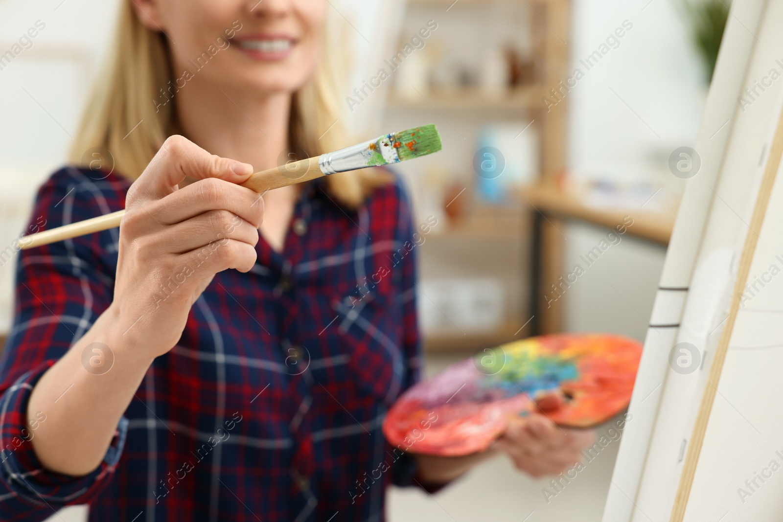 Photo of Woman painting on canvas in studio, selective focus. Creative hobby