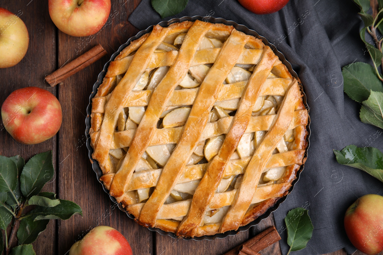 Photo of Delicious traditional apple pie on wooden table, flat lay