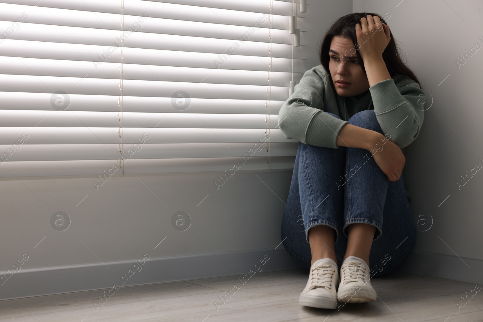 Photo of Sadness. Unhappy woman sitting on floor at home