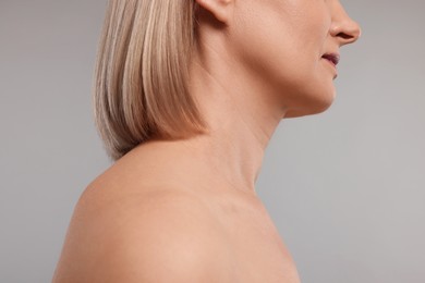 Woman with healthy skin on grey background, closeup