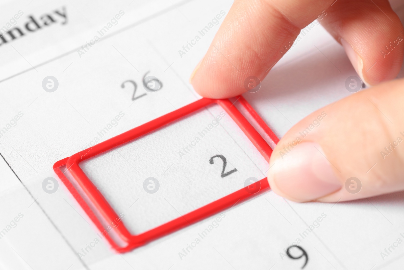 Photo of Woman moving date slider on calendar onto February 2nd, closeup. Groundhog day