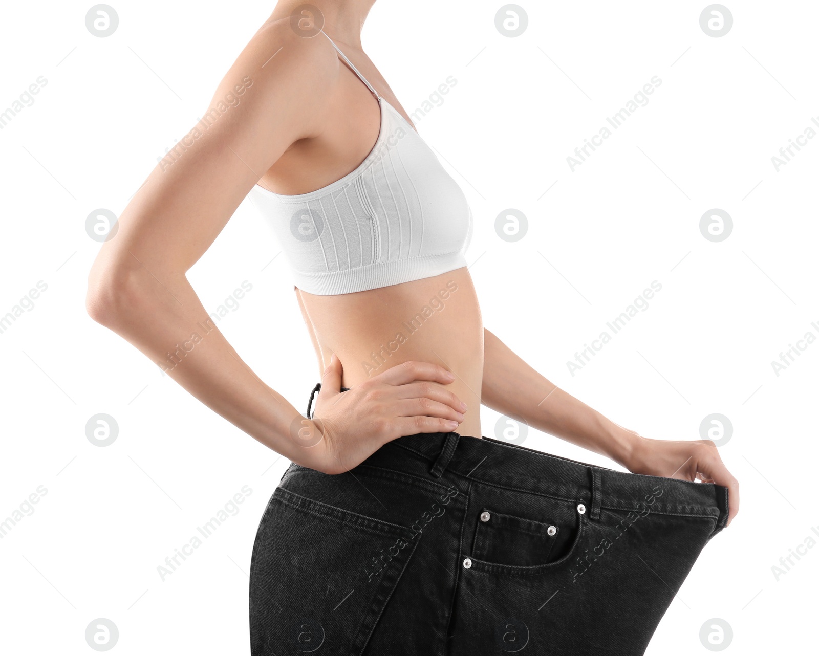 Photo of Young slim woman wearing oversized jeans on white background, closeup