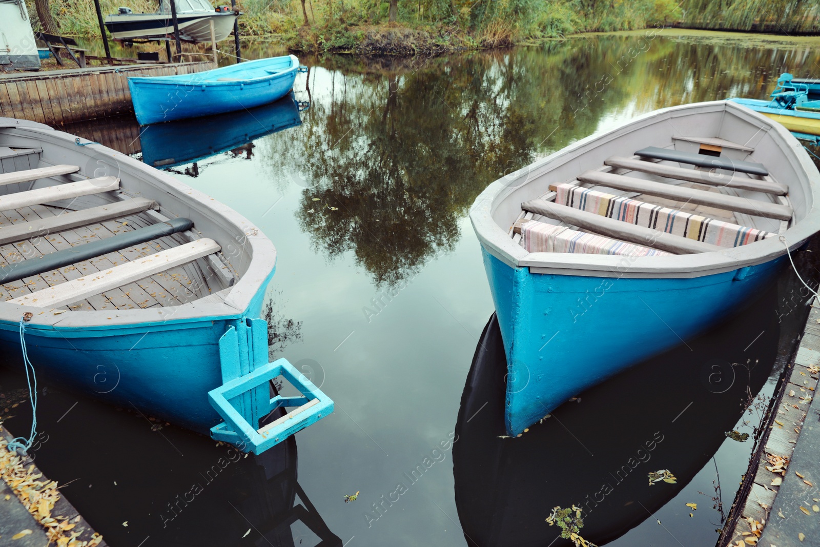 Photo of Old light blue wooden boats on lake