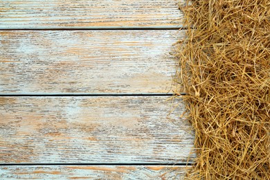 Photo of Heap of dried hay on light wooden background, flat lay. Space for text
