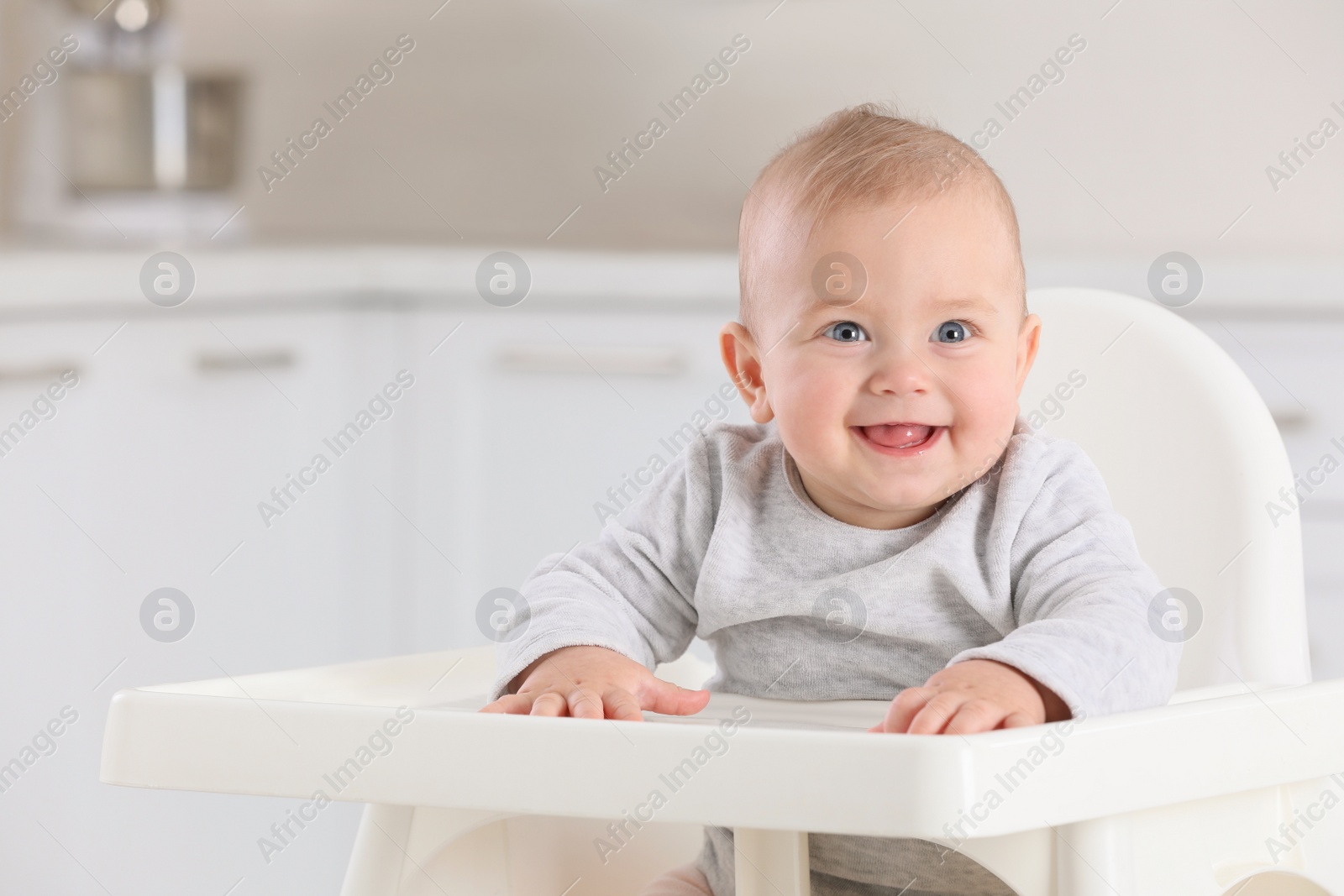 Photo of Cute little baby in high chair at home