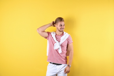 Photo of Young man with trendy hairstyle on color background