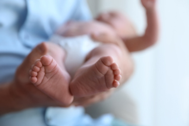 Photo of Father holding his newborn baby at home, closeup