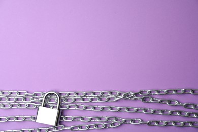 Photo of Steel padlock, chains and space for text on purple background, flat lay. Safety concept