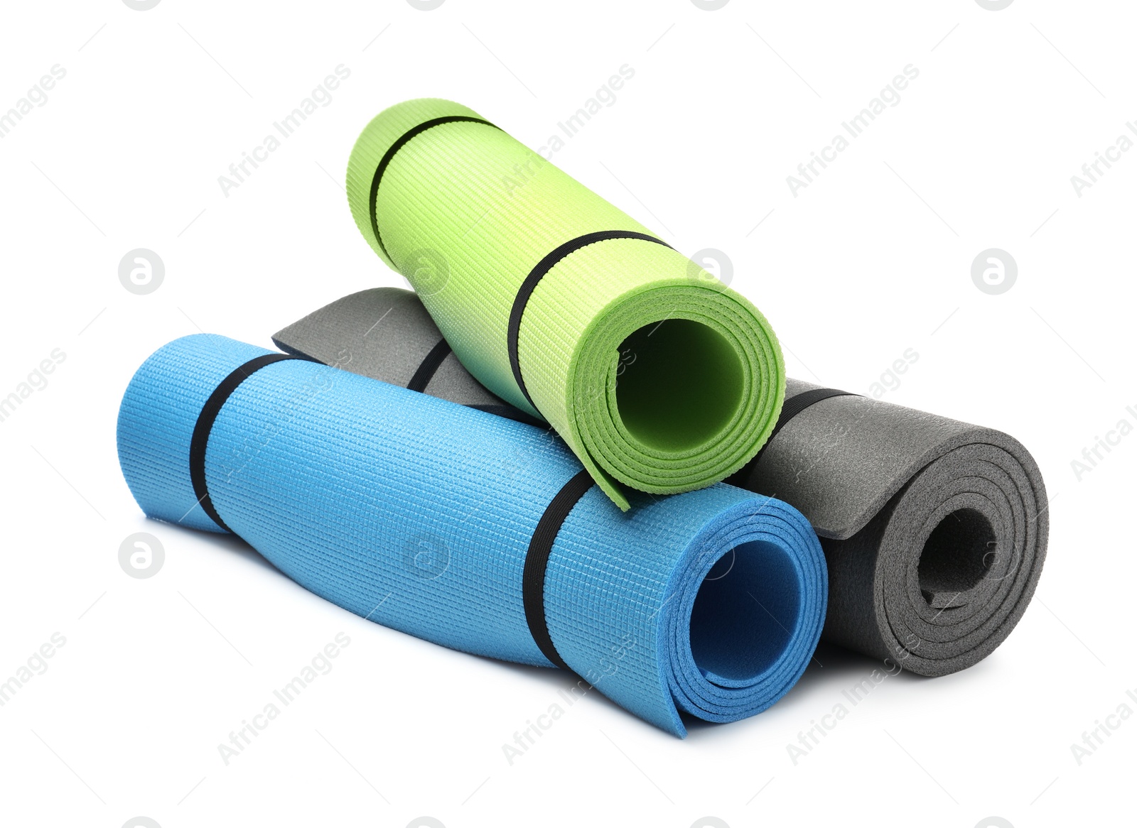 Photo of Colorful rolled camping or exercise mats on white background