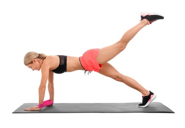 Photo of Woman exercising with elastic resistance band on fitness mat against white background