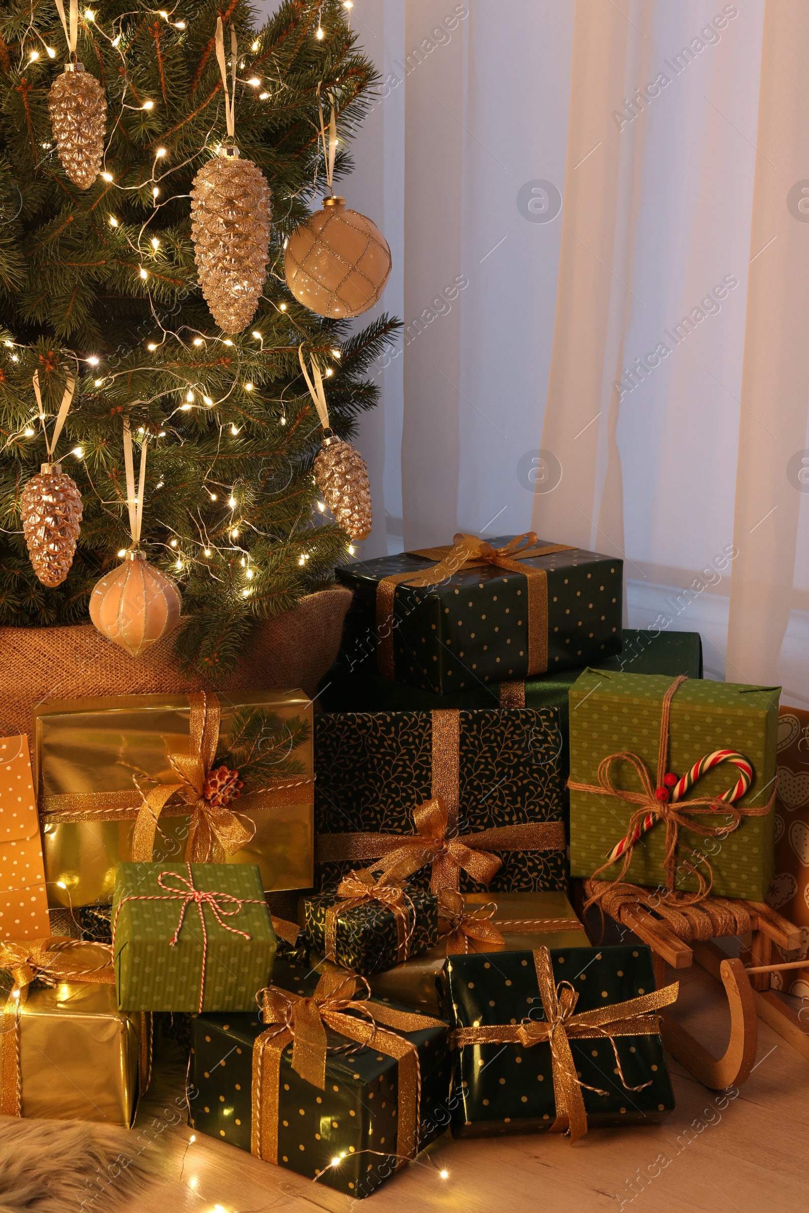 Photo of Many different gifts under Christmas tree indoors