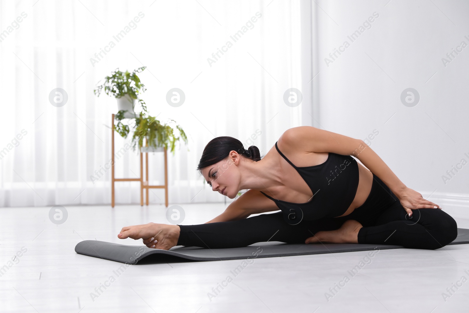 Photo of Professional young acrobat practicing yoga at home