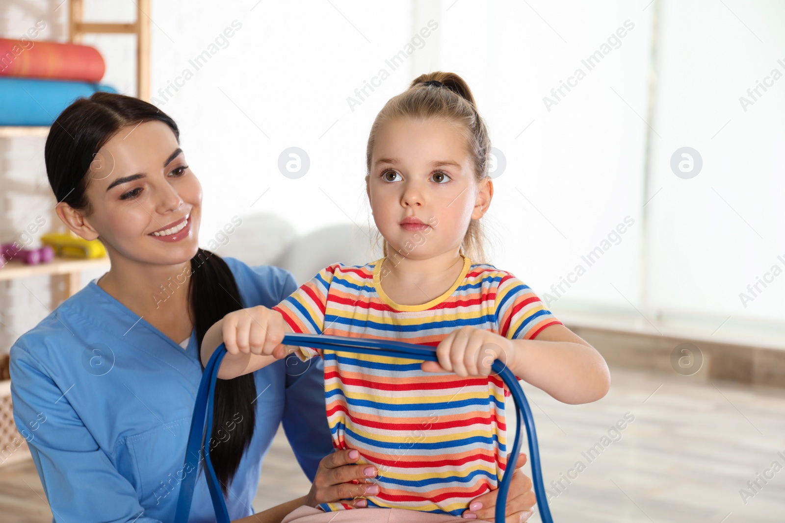 Photo of Orthopedist working with little girl in hospital gym