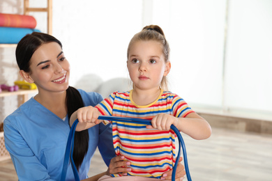 Orthopedist working with little girl in hospital gym