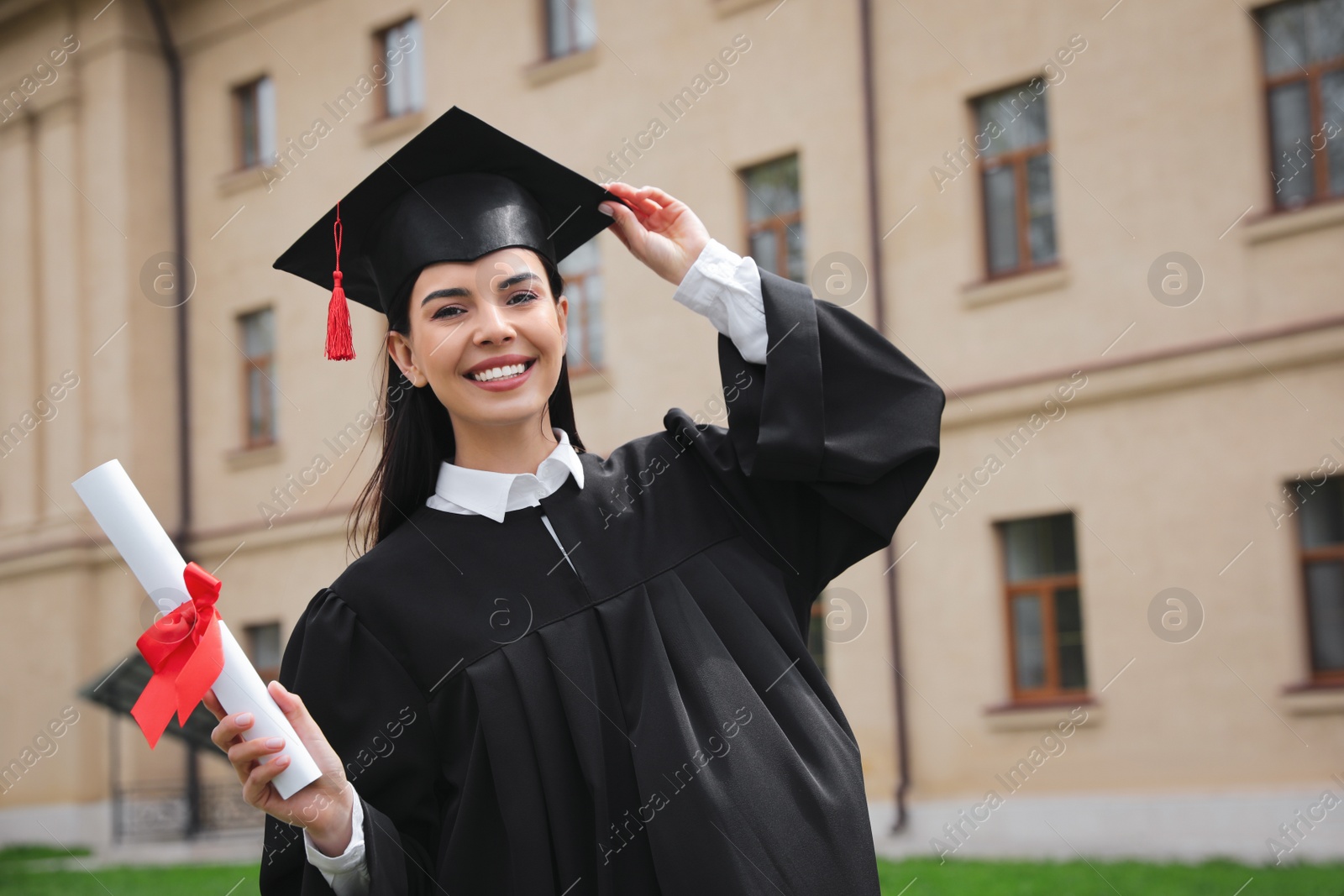 Photo of Happy student with diploma after graduation ceremony outdoors