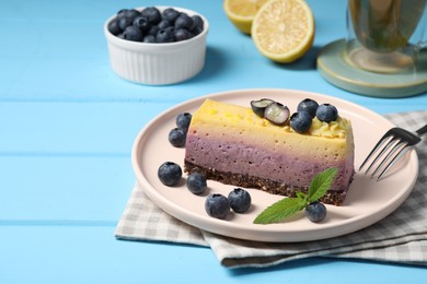 Photo of Delicious cheesecake with blueberry and mint on light blue wooden table. Space for text