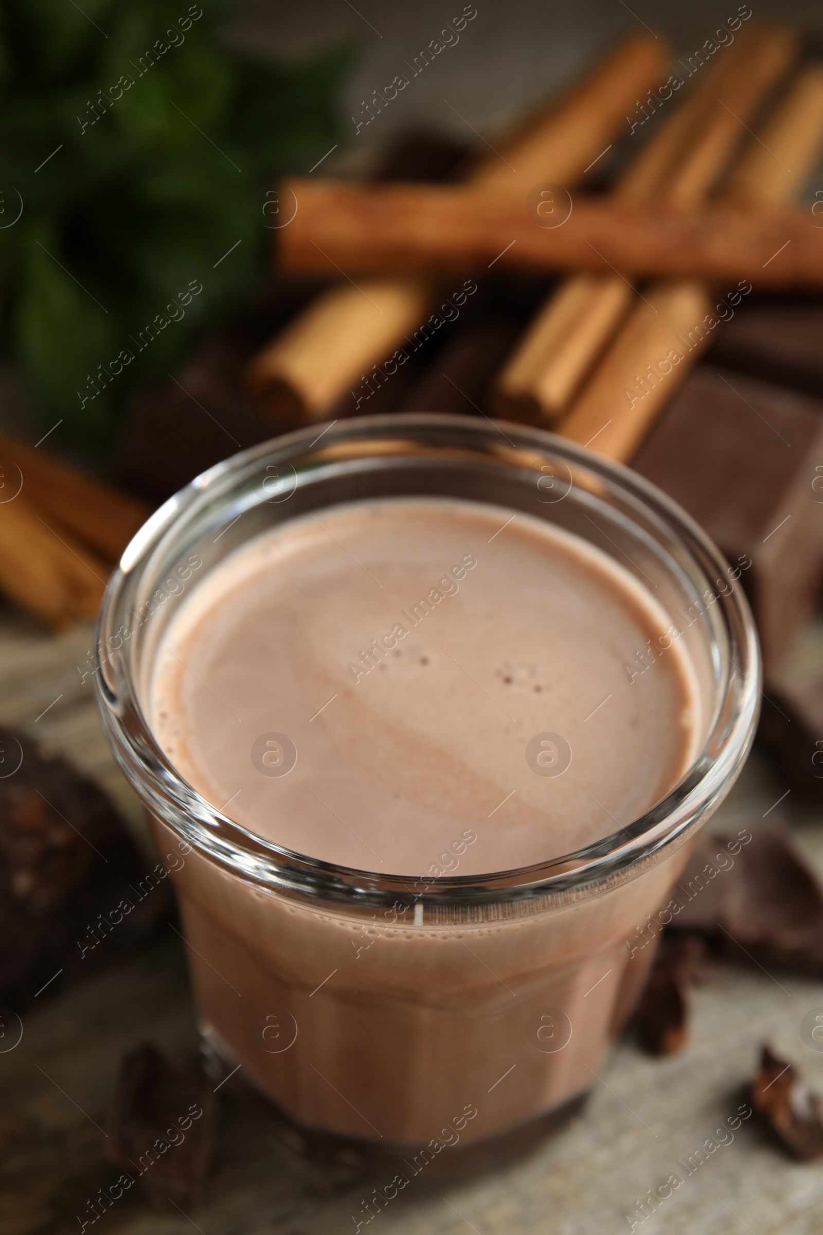 Photo of Glass of delicious hot cocoa on wooden table, closeup