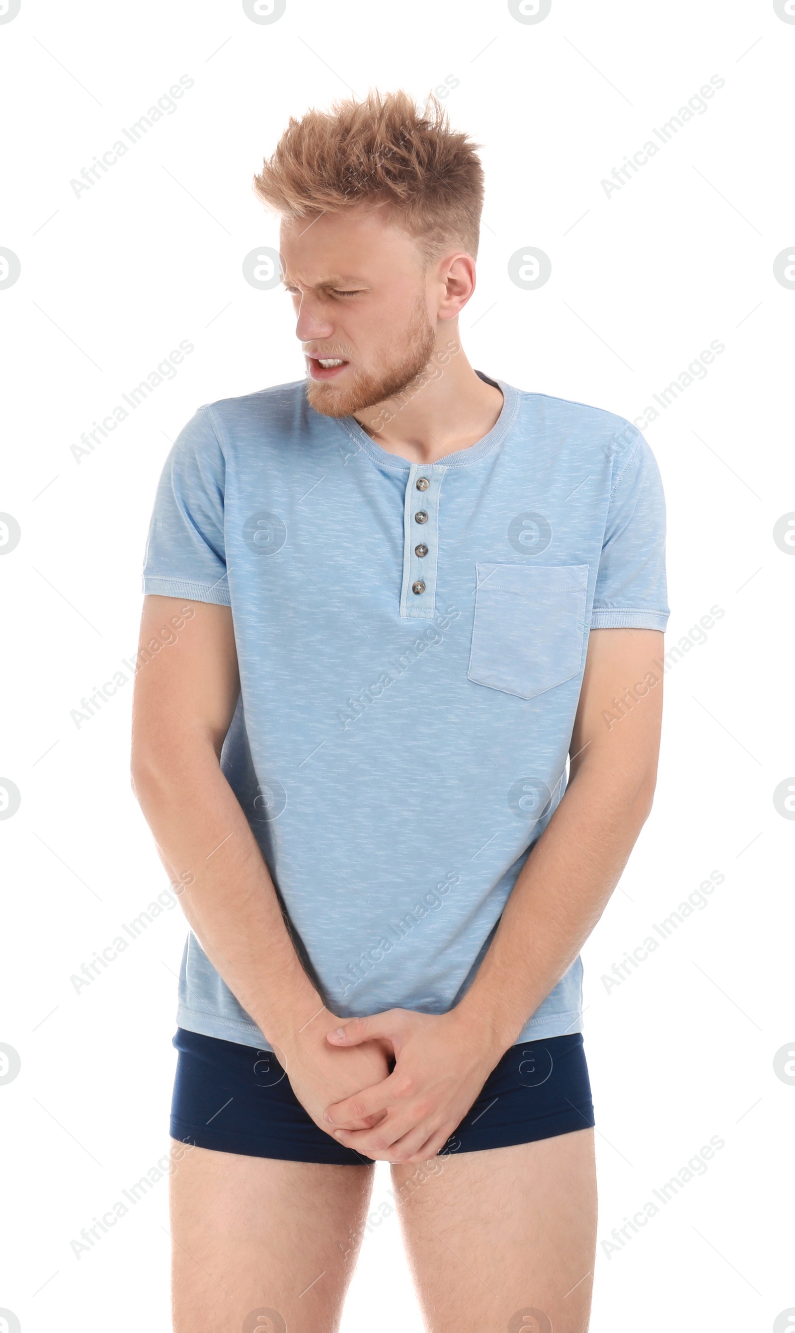 Photo of Young man suffering from pain on white background. Urology problems