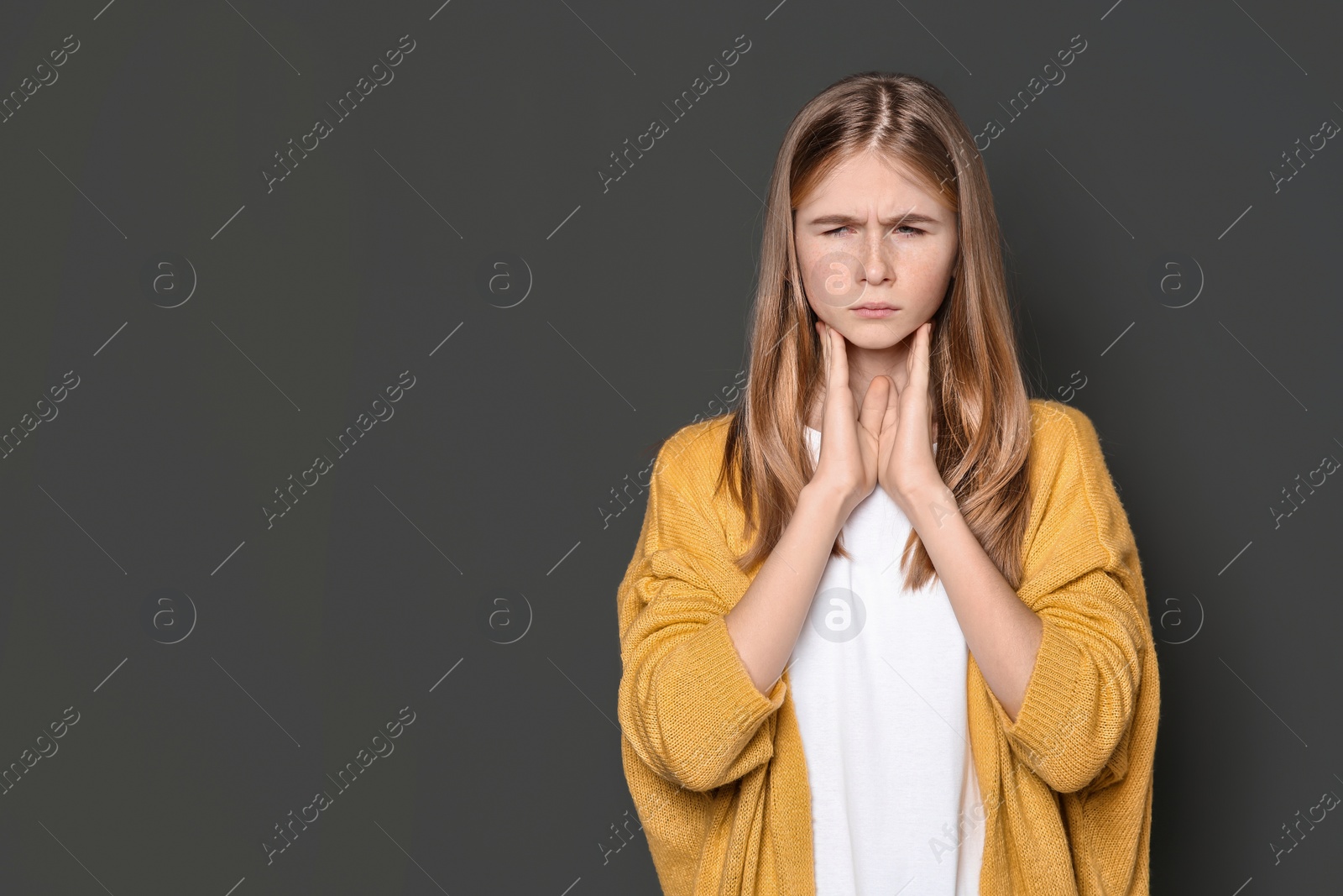 Photo of Teenage girl suffering from cough on dark background. Space for text