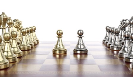 Chess pieces on wooden board against white background