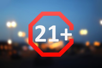 Image of Age limit sign 21+ years and blurred view of night city