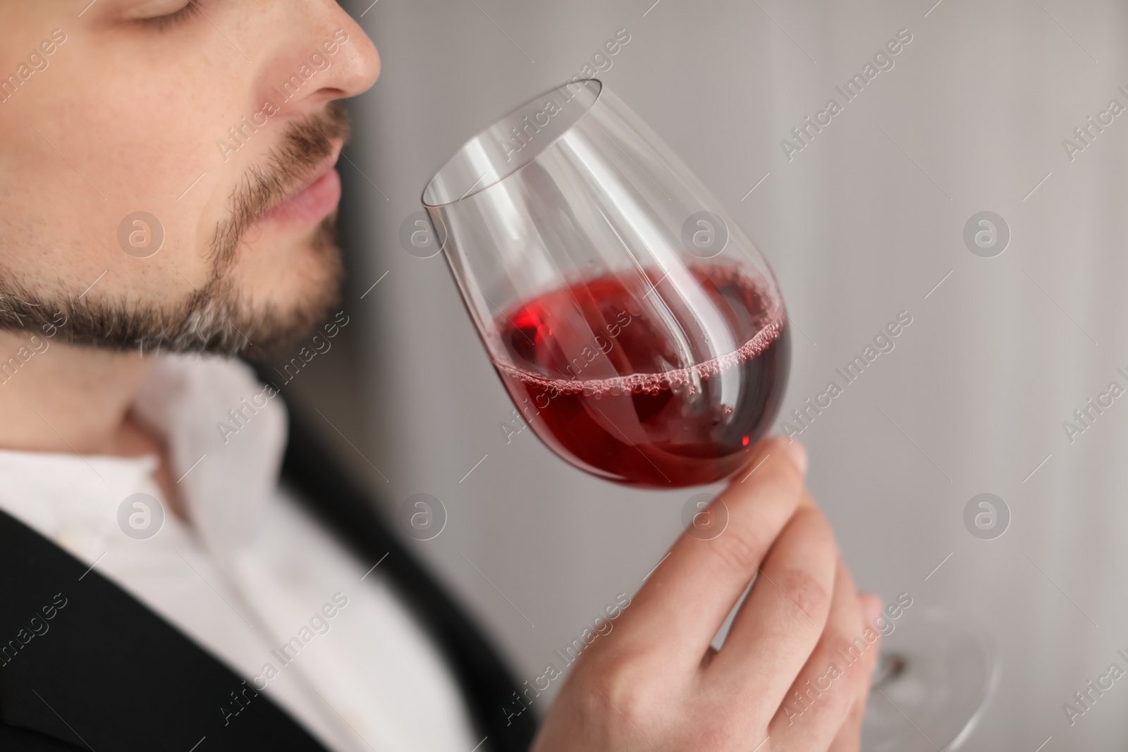 Photo of Young man with glass of wine indoors