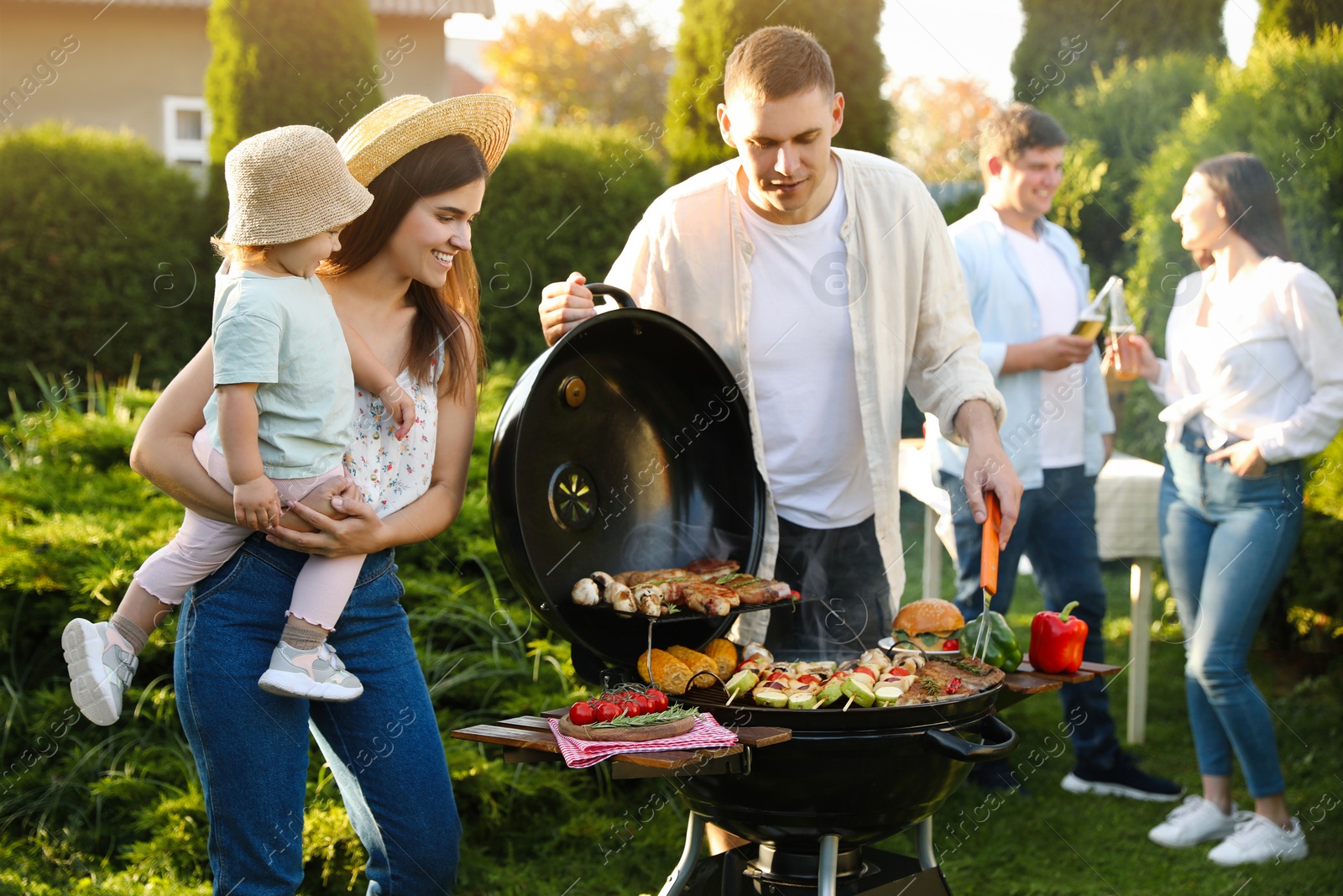 Photo of Family with friends having barbecue party outdoors