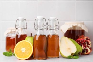 Photo of Tasty kombucha, fresh fruits and mint on white table