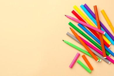 Photo of Many bright markers on beige background, flat lay. Space for text