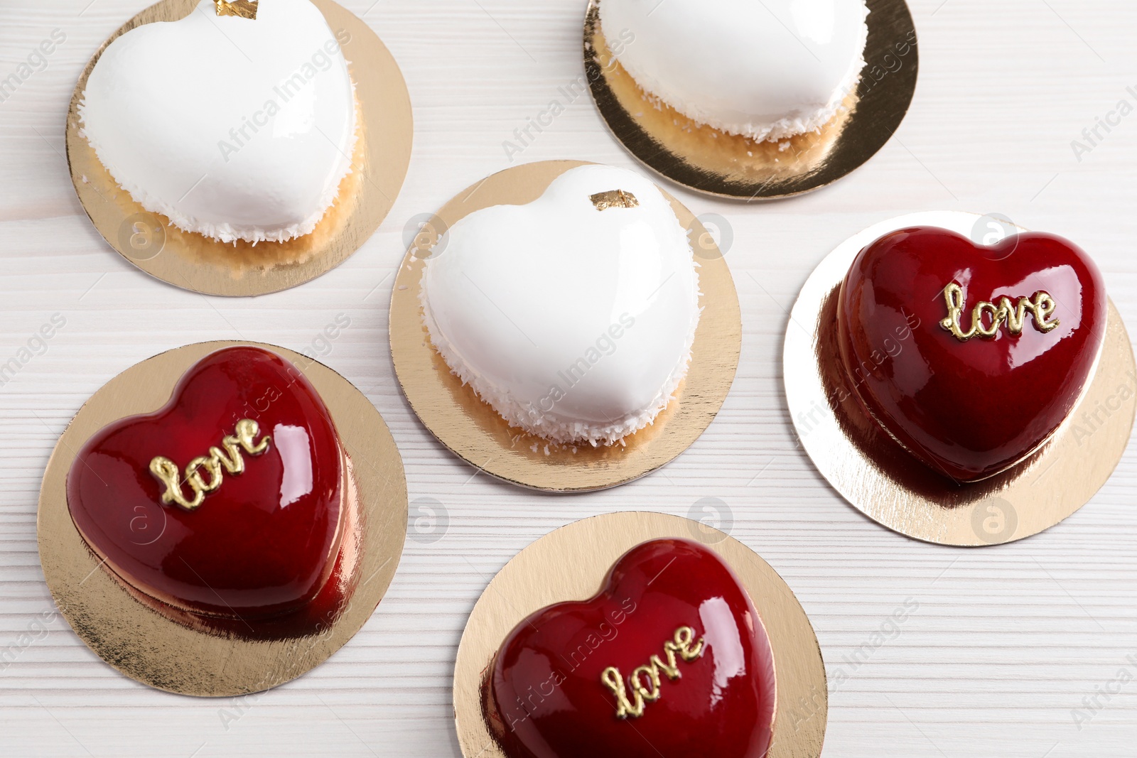 Photo of St. Valentine's Day. Delicious heart shaped cakes on white wooden table, above view