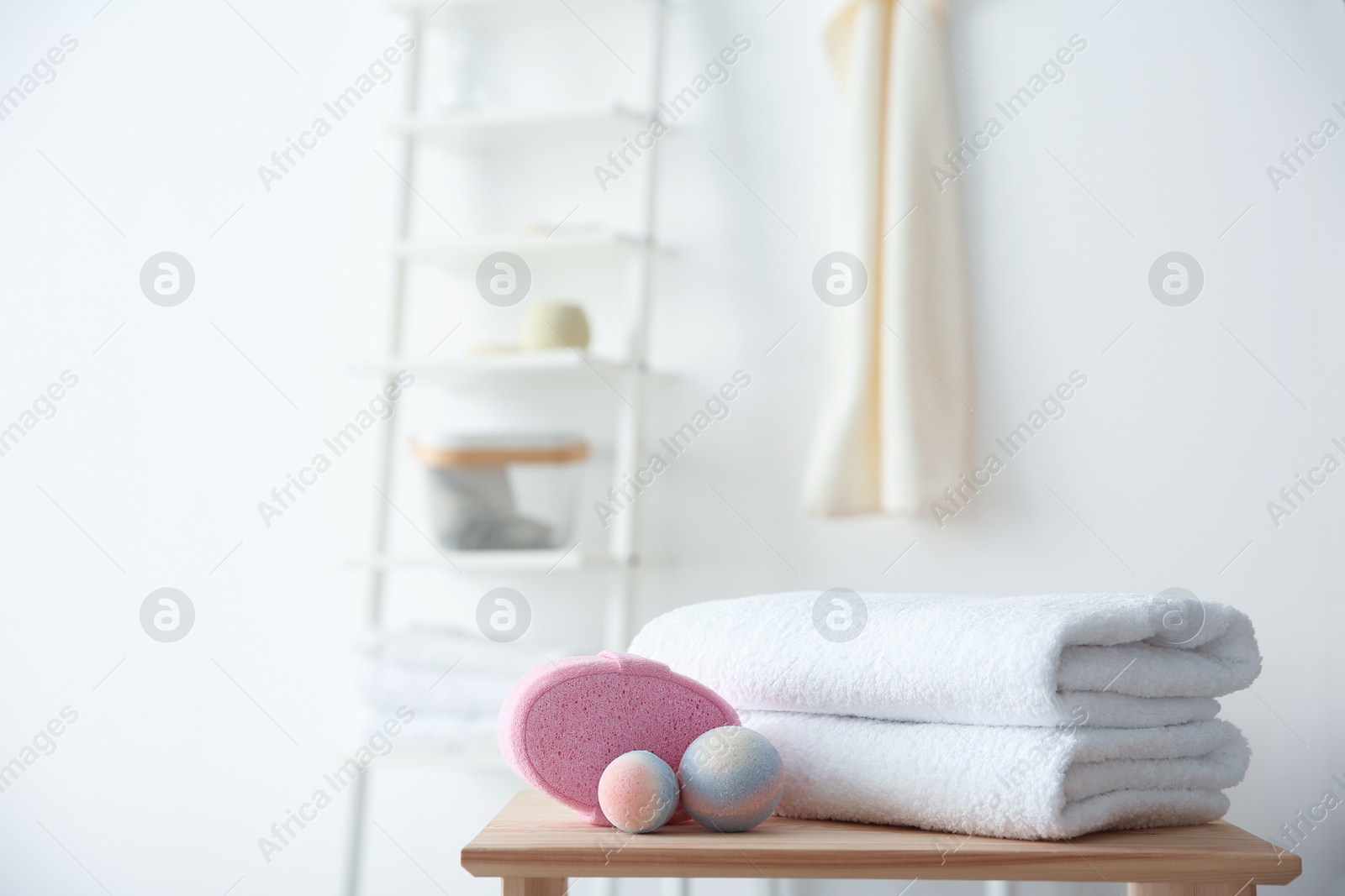 Photo of Clean towels and toiletries on table against blurred background