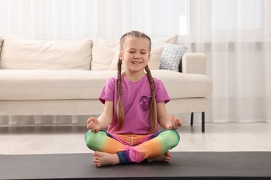 Little girl meditating at home. Harmony and zen