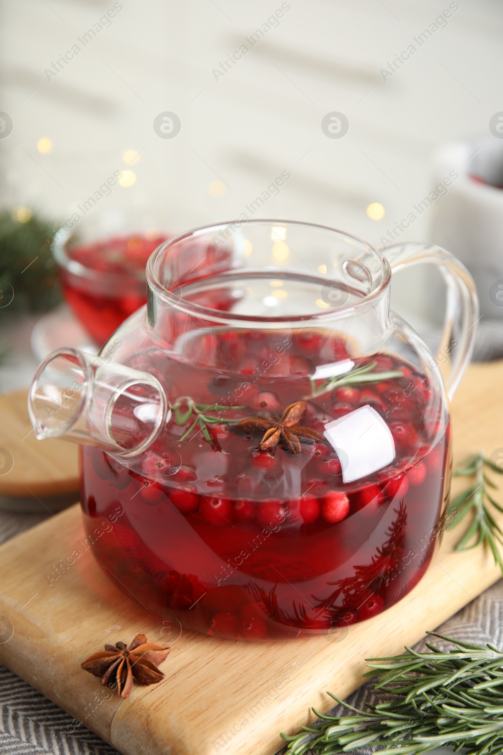 Photo of Tasty hot cranberry tea with rosemary and anise on table
