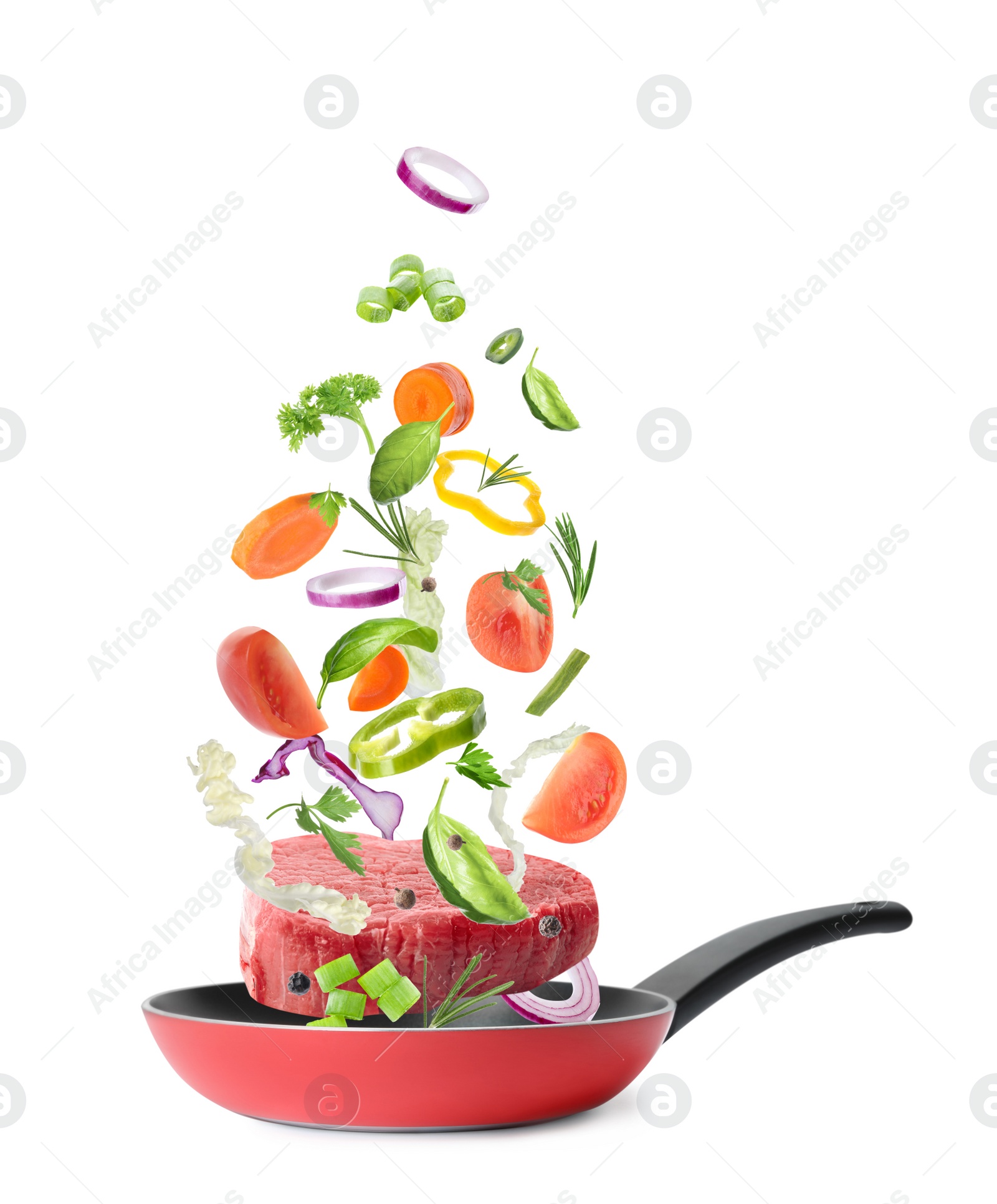 Image of Different vegetables and beef slice falling into frying pan on white background. Process of cooking