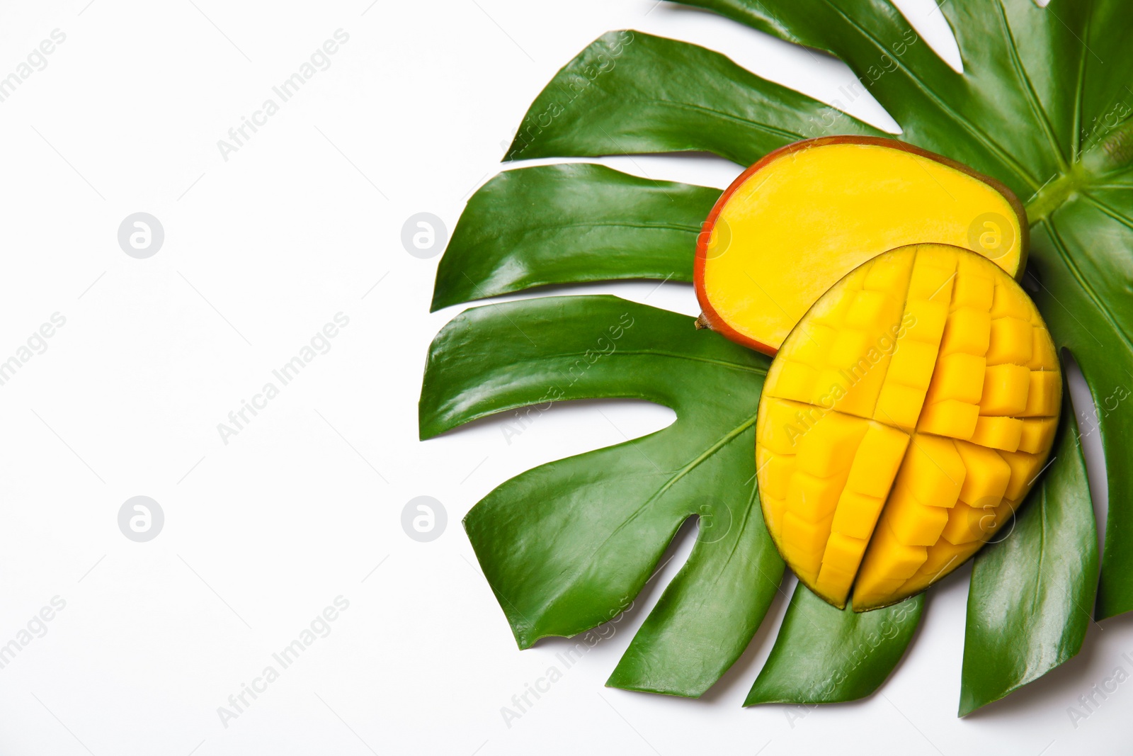 Photo of Juicy mango and green tropical leaf isolated on white, top view. Space for text