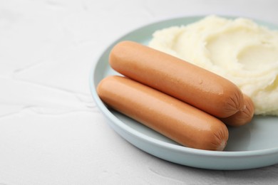 Photo of Delicious boiled sausages and mashed potato on white textured table, closeup. Space for text