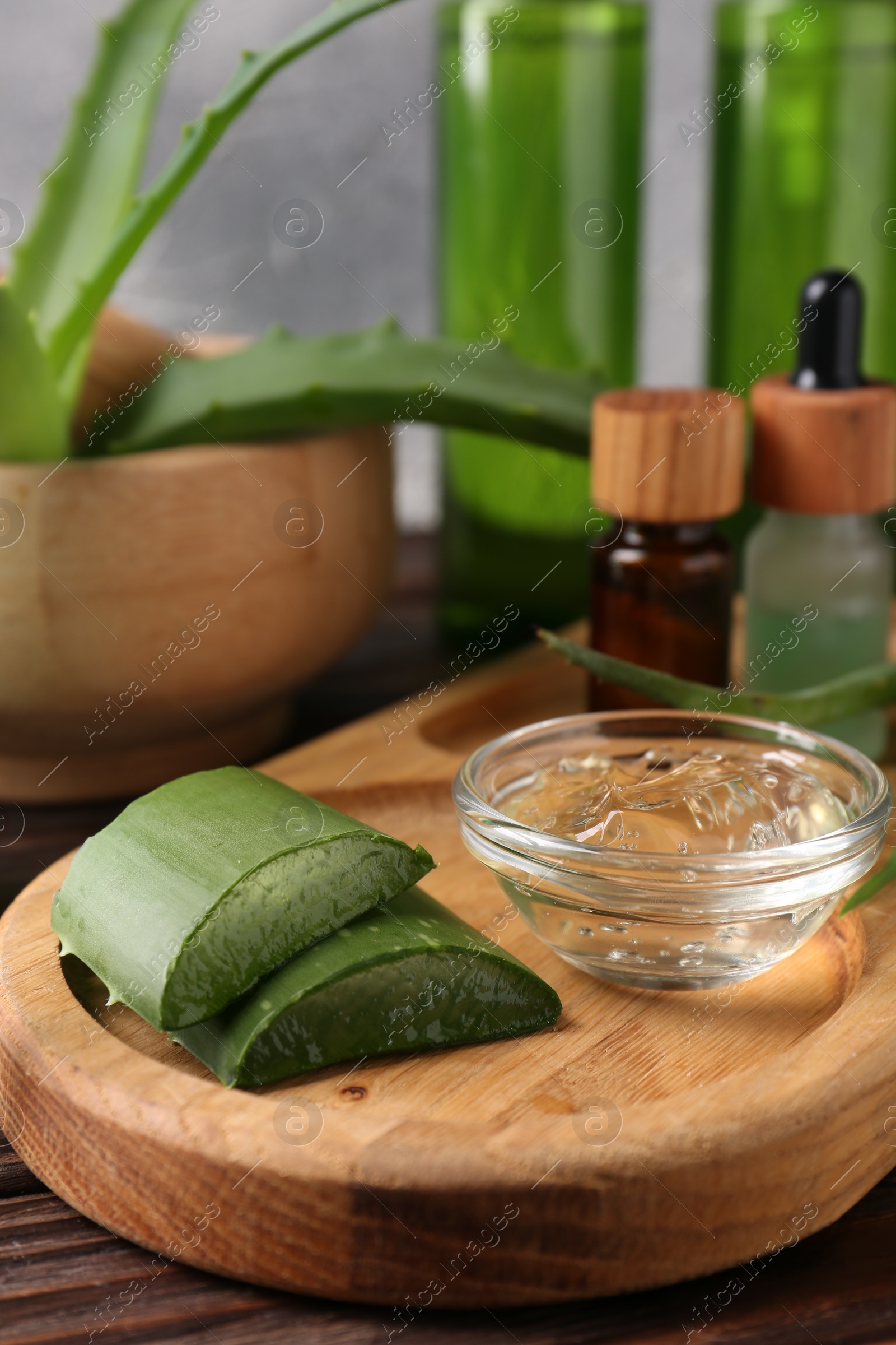Photo of Homemade aloe gel and fresh ingredients on wooden table, closeup