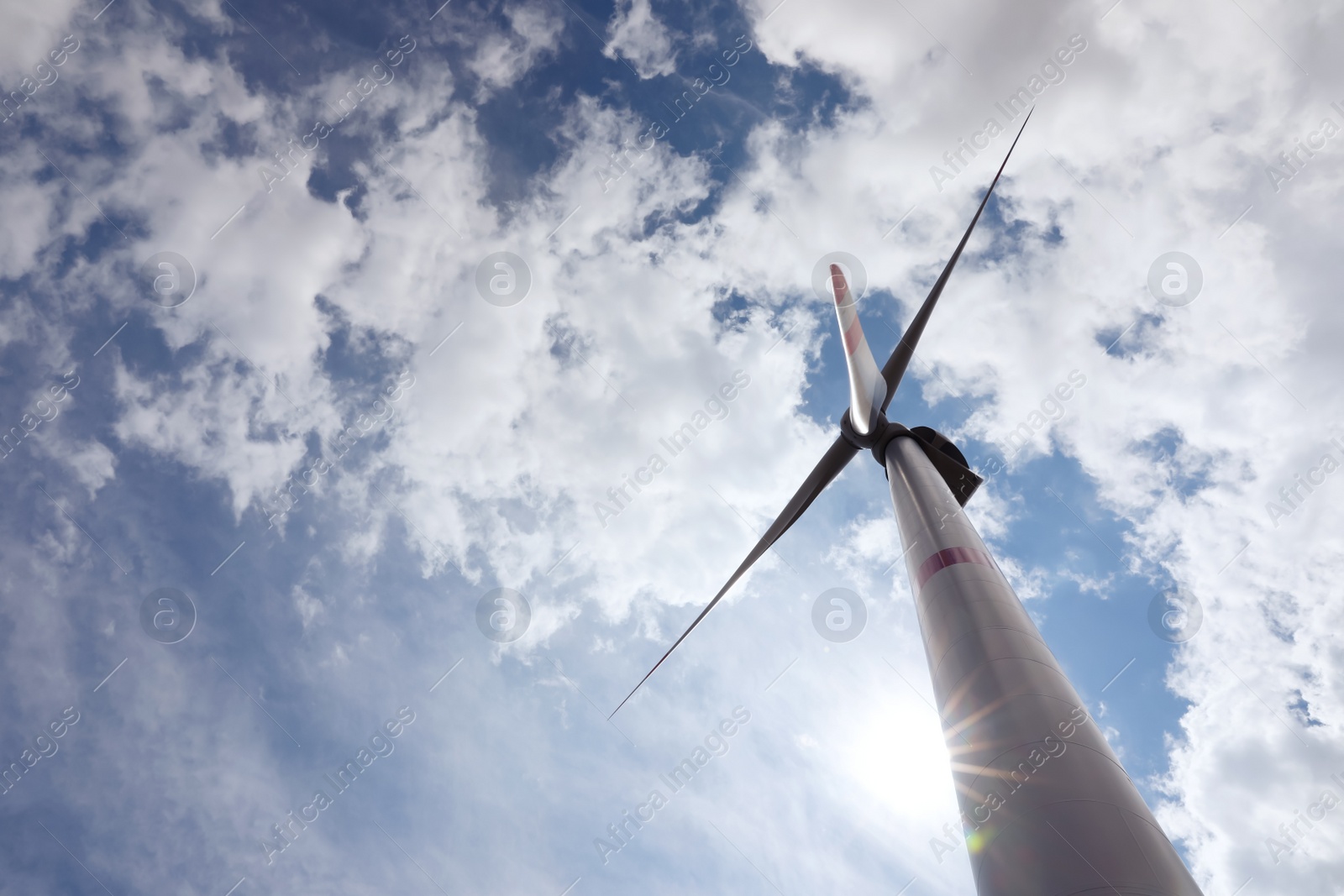 Photo of Modern wind turbine against cloudy sky, low angle view. Alternative energy source