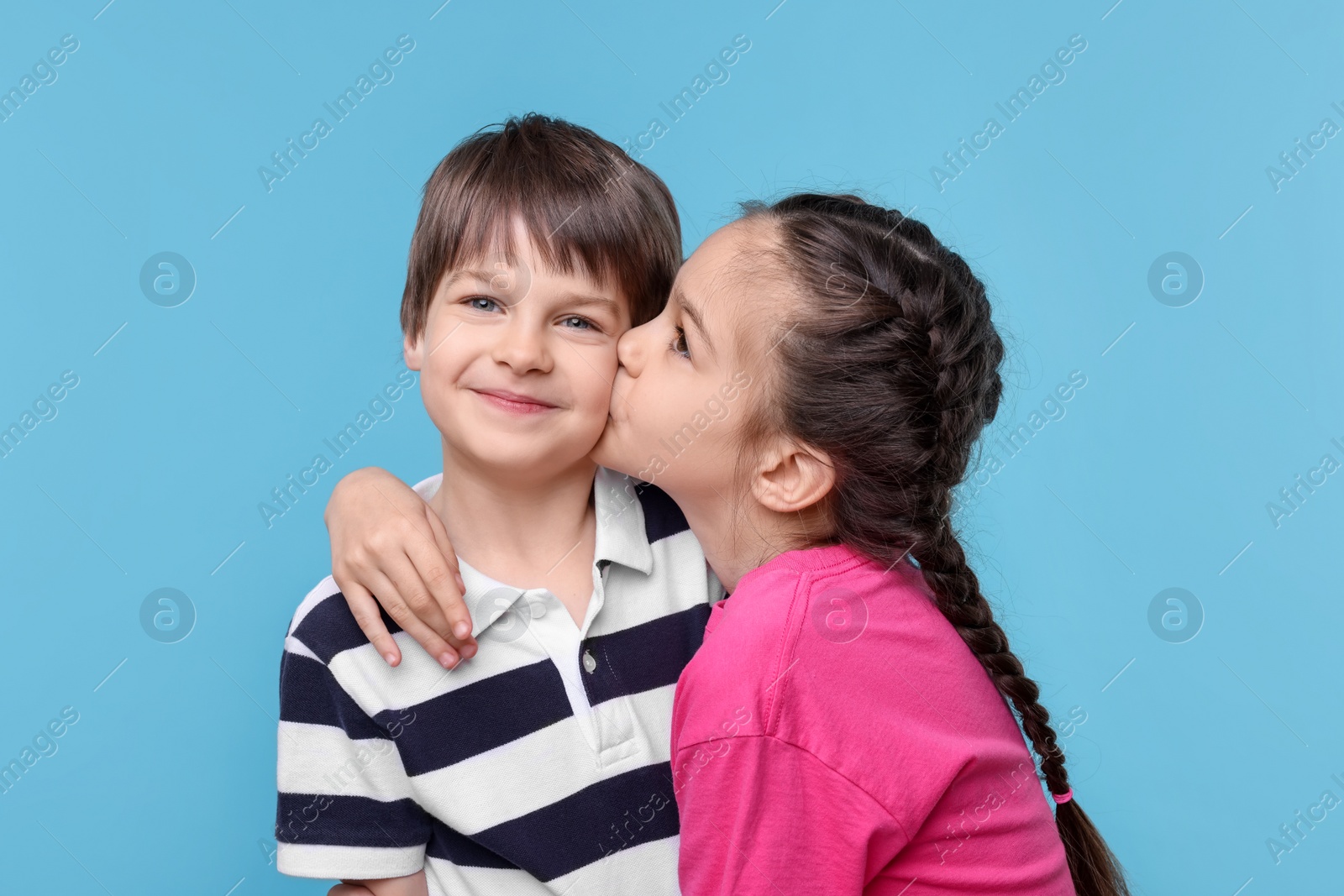 Photo of Happy brother and sister on light blue background