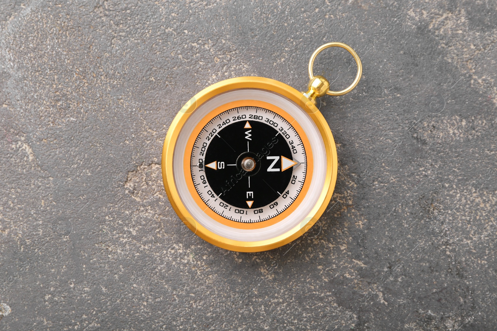 Photo of One compass on grey textured background, top view