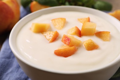 Photo of Delicious yogurt with fresh peach in bowl, closeup