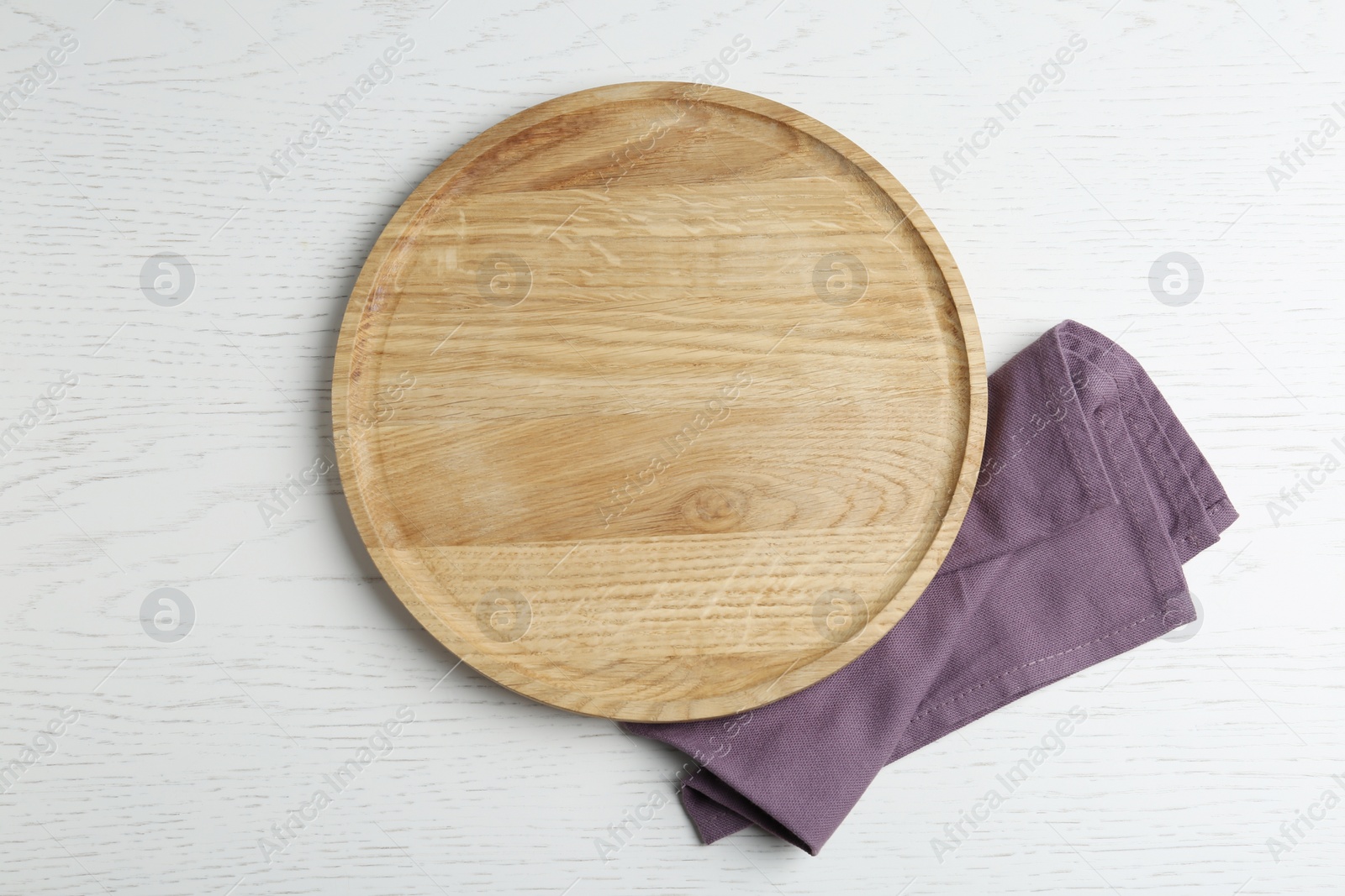 Photo of Empty wooden serving board and napkin on white table, flat lay