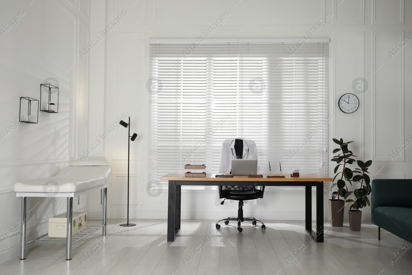 Photo of Modern medical office interior with doctor's workplace and examination table