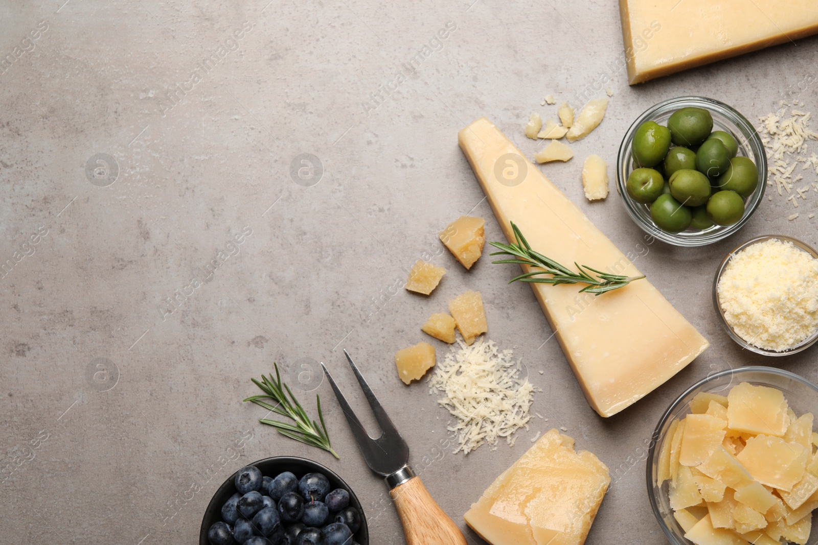 Photo of Flat lay composition with parmesan cheese on grey table. Space for text