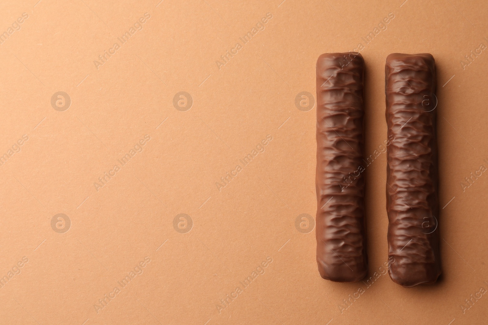 Photo of Sweet tasty chocolate bars on beige background, top view. Space for text