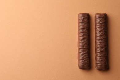 Photo of Sweet tasty chocolate bars on beige background, top view. Space for text