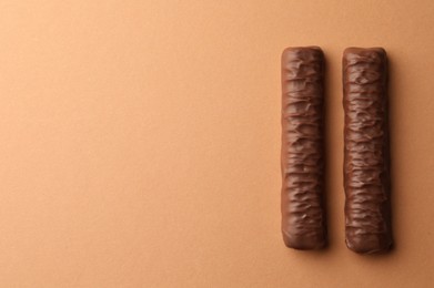 Sweet tasty chocolate bars on beige background, top view. Space for text