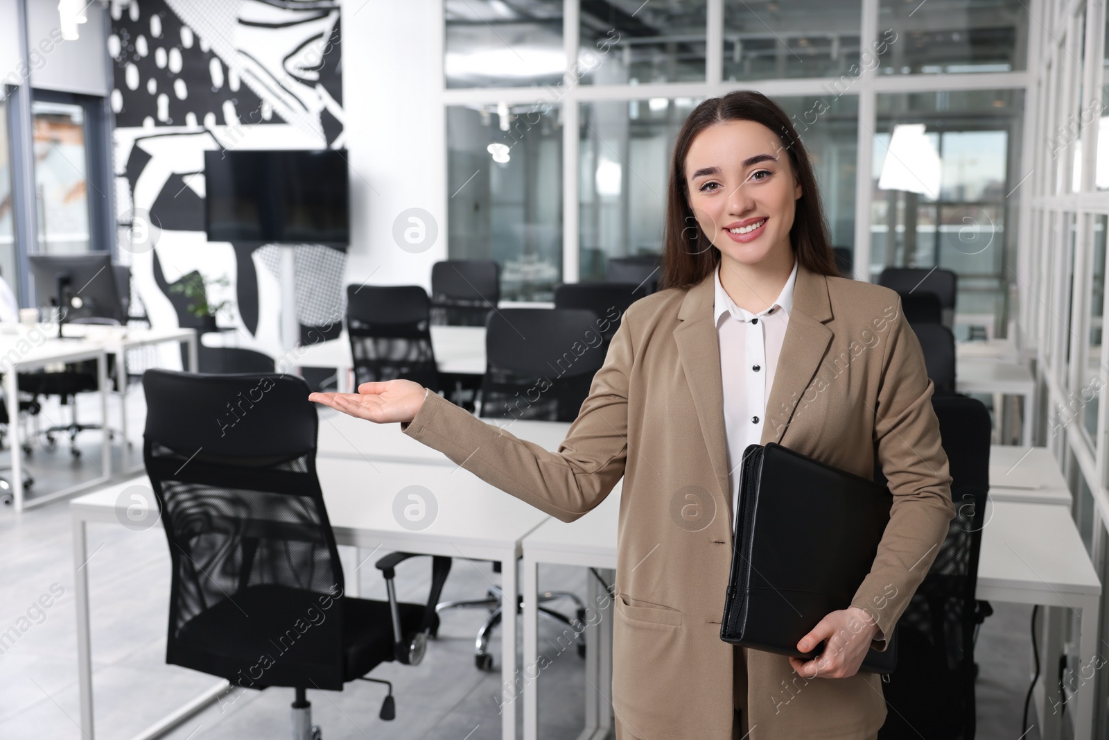 Photo of Happy real estate agent with leather portfolio in office