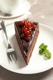 Plate with slice of chocolate cake and berries on table